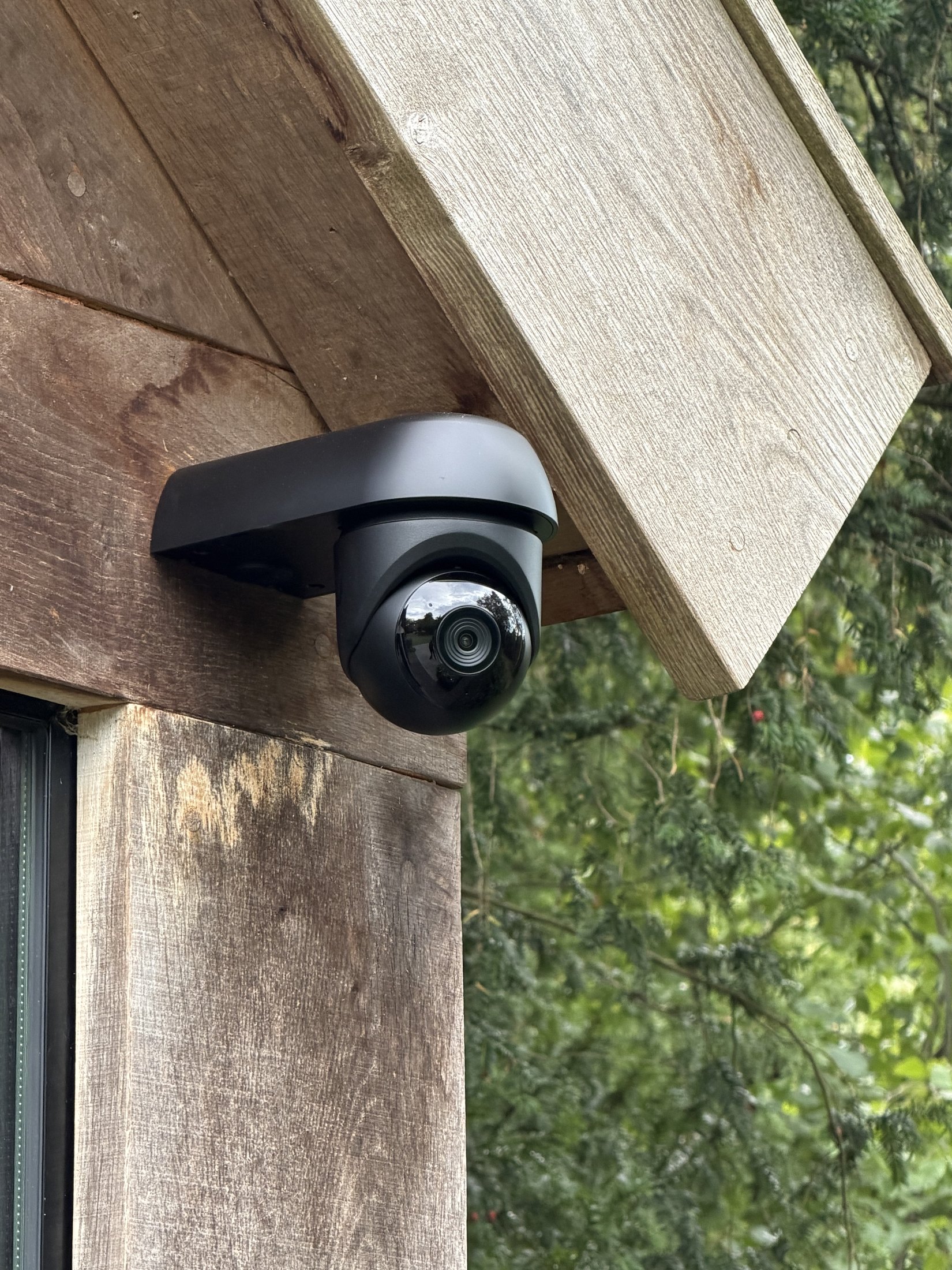 Kleine zwarte camera op de houten balk van een veranda