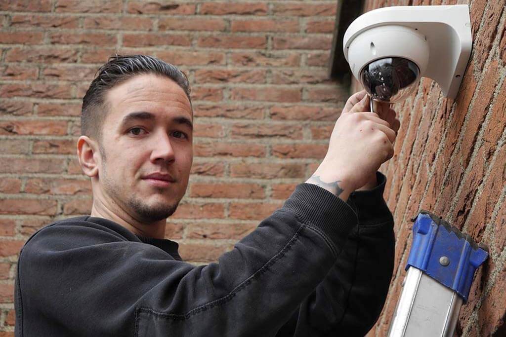 Dave stelt een dome-camera af vanaf de ladder