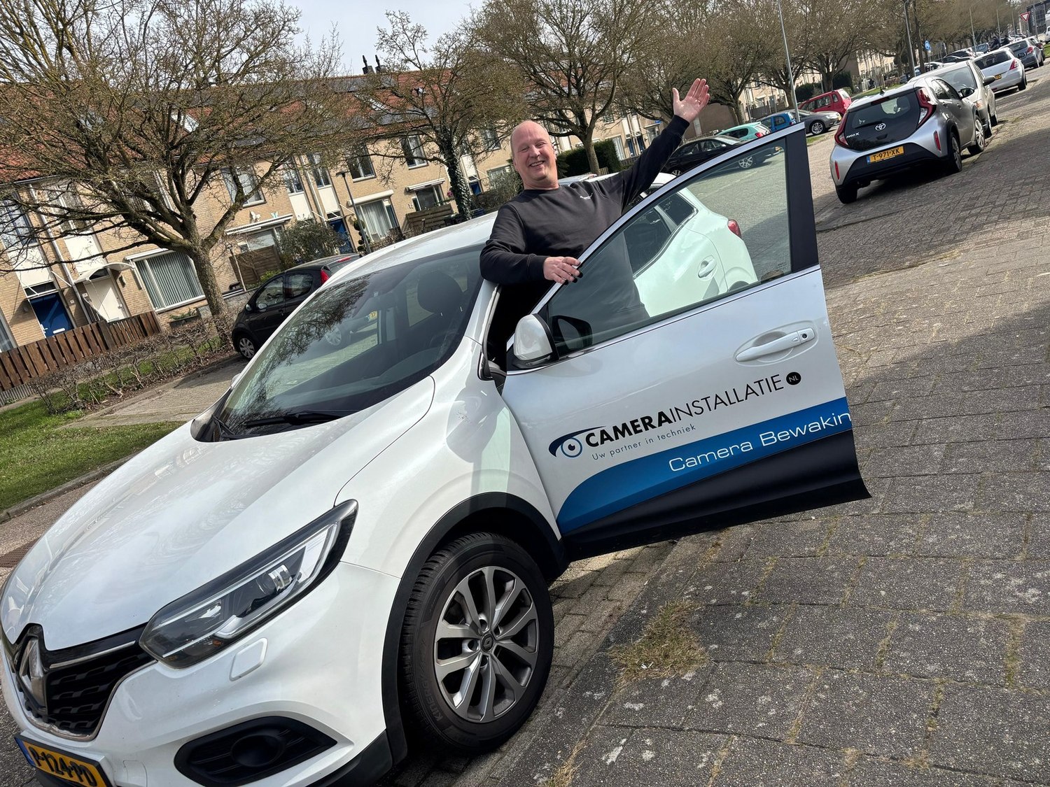 Collega zwaait vrolijk bij het instappen in zijn servicewagen