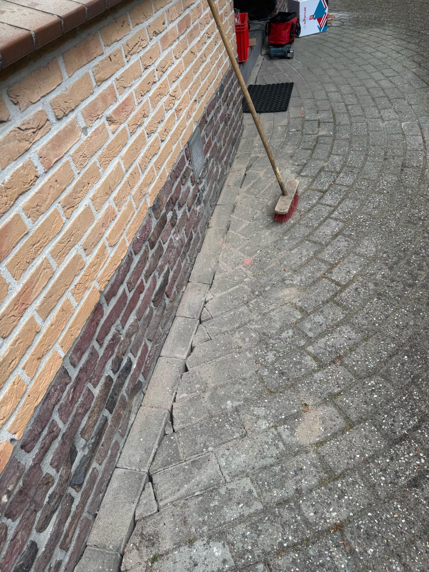 De klinkers liggen terug langs de gevel, het tracé is niet meer te zien