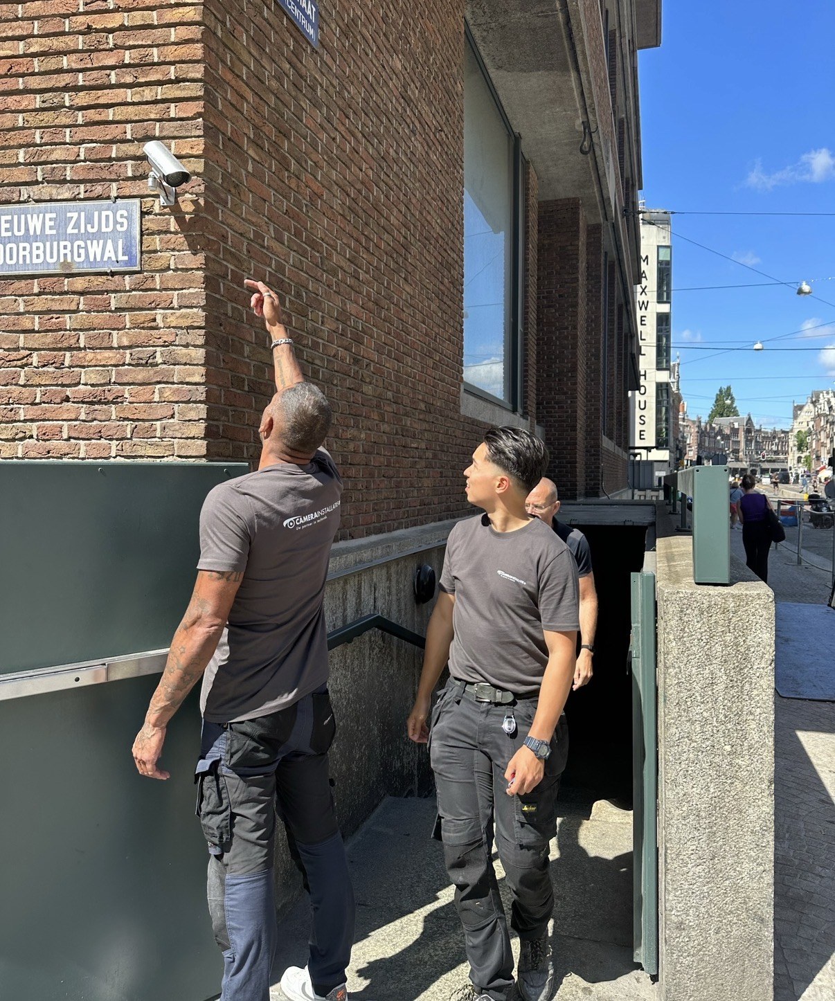 Twee monteurs bepalen samen de camerapositie aan de gevel
