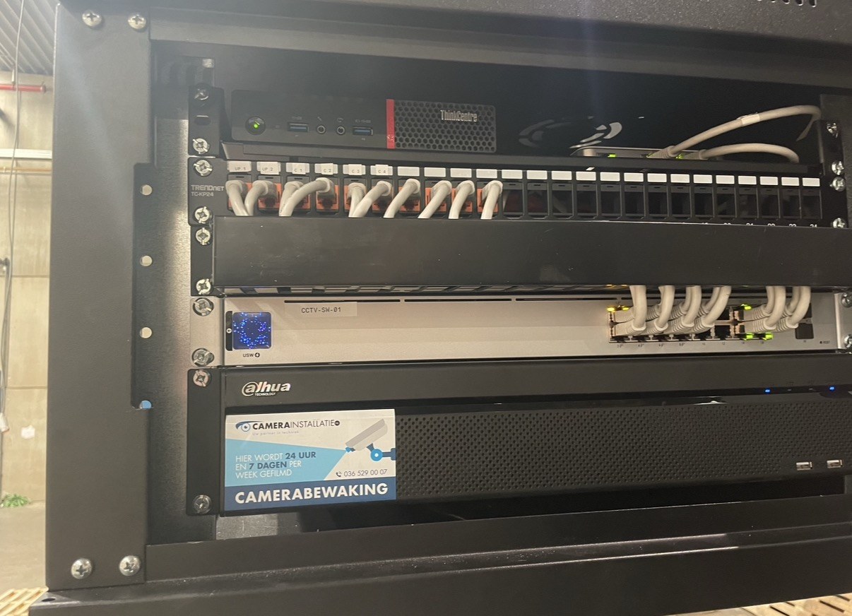 Patchkast met recorder en netwerkswitch, netjes afgemonteerd en gelabeld