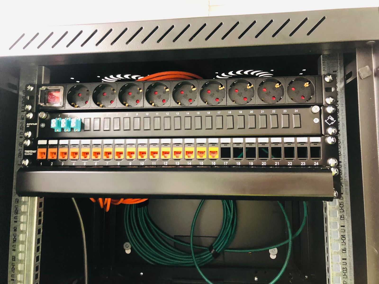 Nette technische kast met netwerkapparatuur en stroomverdeling, kabels strak opgelegd