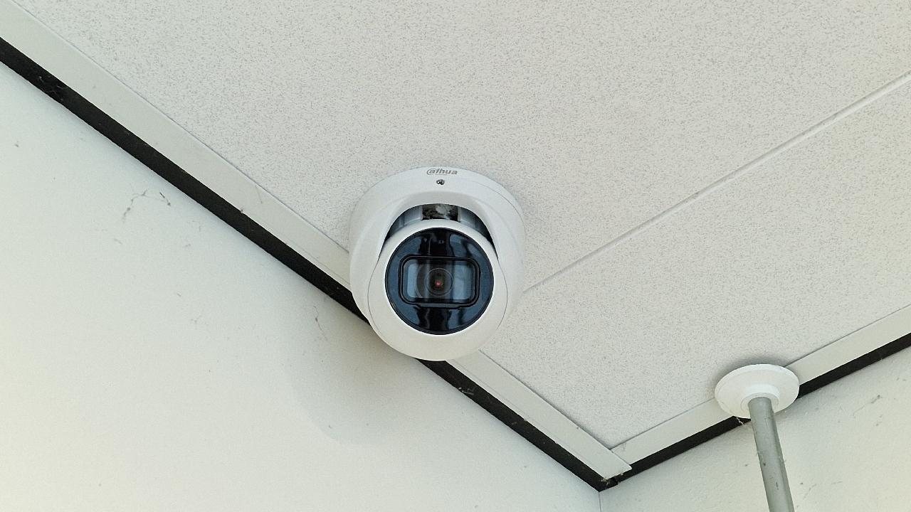 Witte dome-camera in een systeemplafond van een school