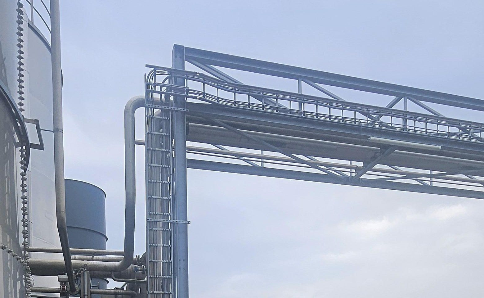 Stalen pijpbrug op een productieterrein met camera's