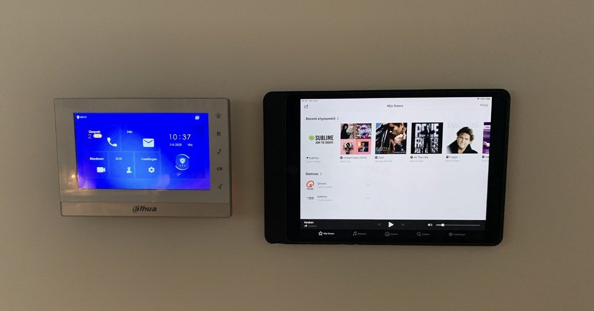 Twee bedieningsschermen aan een wand, voor licht, beveiliging en audio