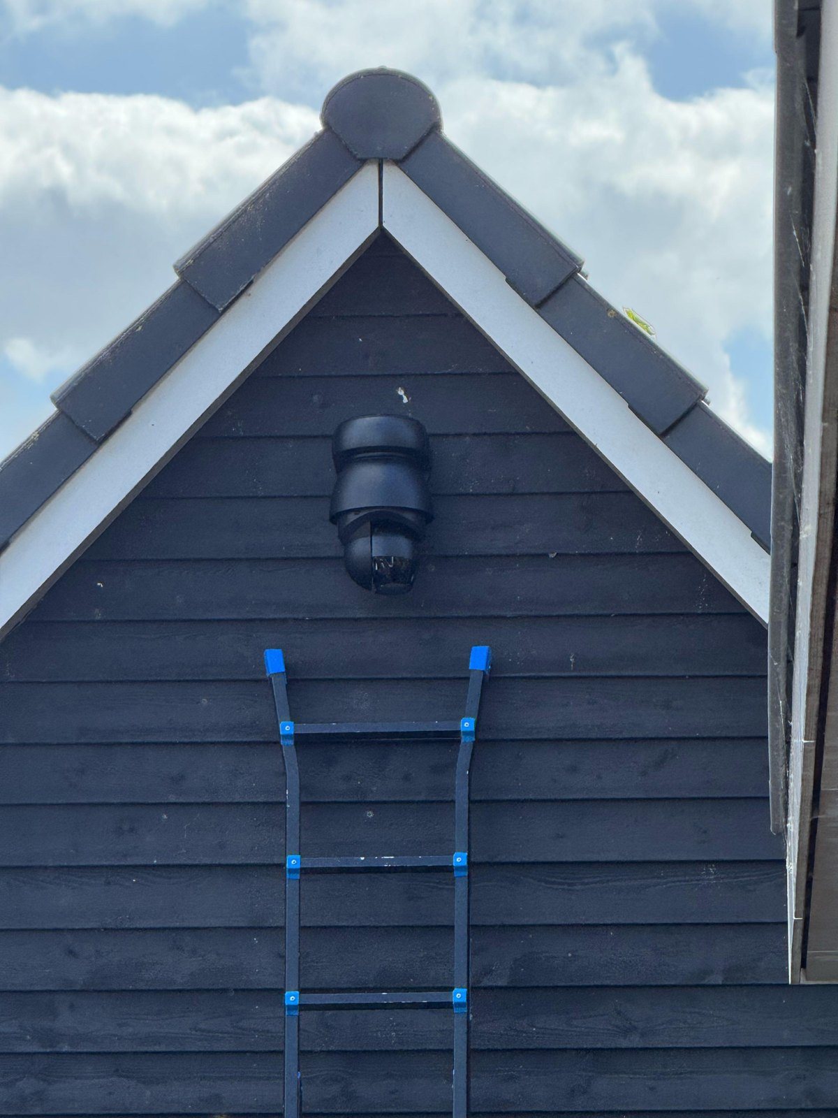 Donkere houten schuur met een draaibare camera in de top van de gevel