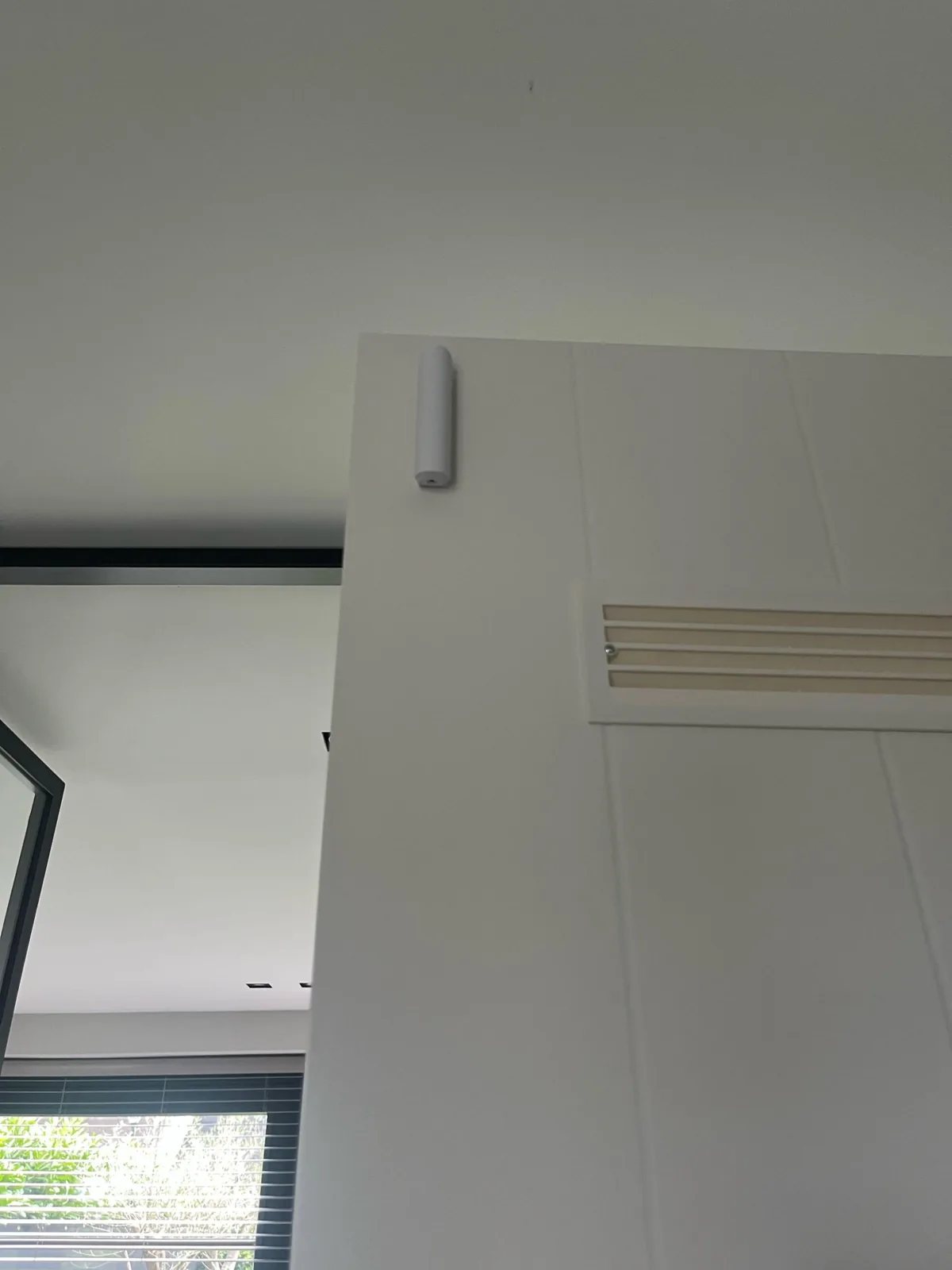Wit contact boven op een witte binnendeur met ventilatierooster
