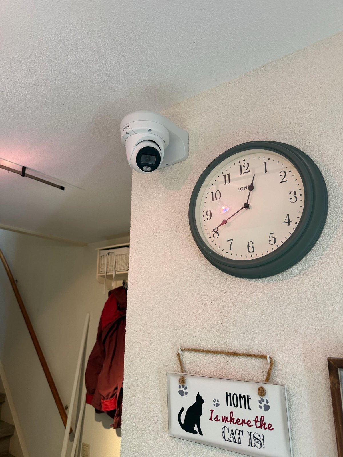 Witte camera hoog in de hoek van een gang, naast een klok